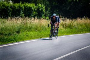 Equipaggio tandem lungo una strada con campagna intorno