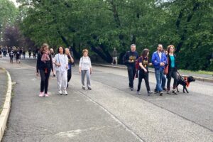 Un gruppo di camminatori con un cane, durante la manifestazione "Oltre la vista oltre la SLA", 2023.